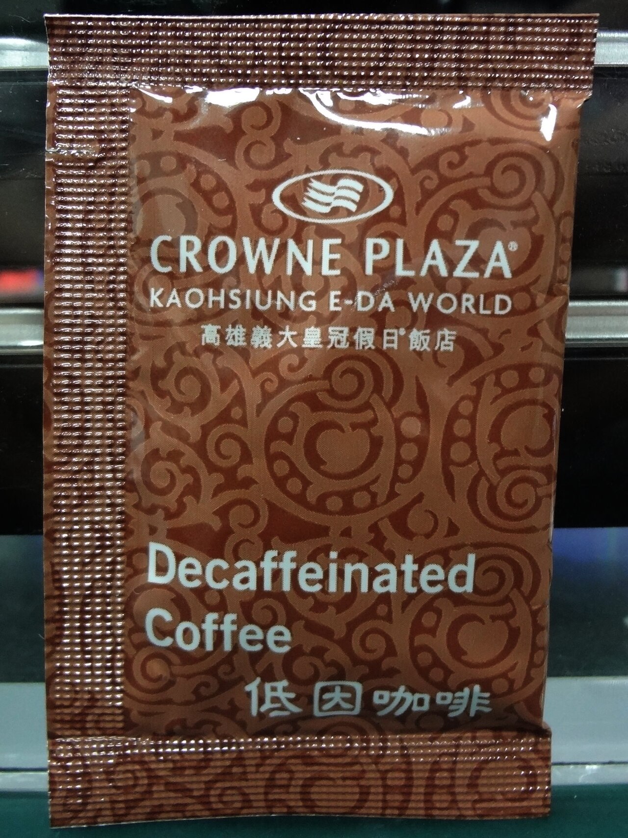 갈색 커피 봉지 앞면에 적힌 ‘Decaffeinated Coffee’ 문구와 크라운 플라자 호텔 로고